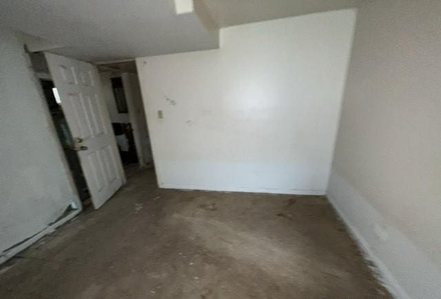 unfurnished room with unfinished concrete floors