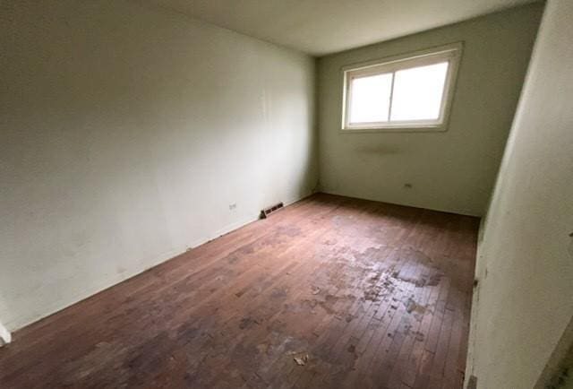 empty room featuring visible vents and wood finished floors