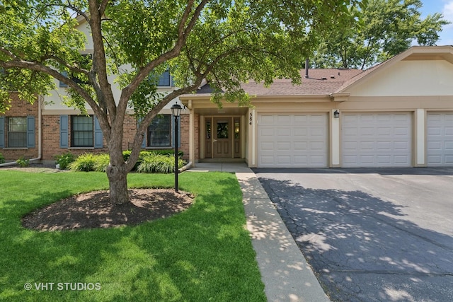 584 Williamsburg Ct Unit C2, Wheeling, IL 60090 - view of front of home featuring asphalt driveway, a front lawn, a garage, and brick siding
