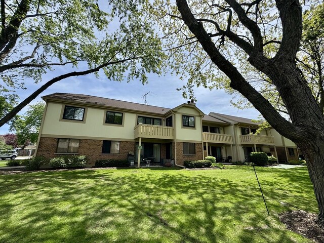 584 Williamsburg Ct Unit C2, Wheeling, IL 60090 - view of property featuring brick siding, asphalt driveway, a front yard, and a garage