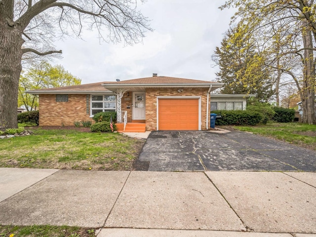 ranch-style house with a front yard, brick siding, a garage, and aphalt driveway