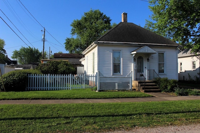 bungalow-style house with a chimney, a front yard, and fence private yard