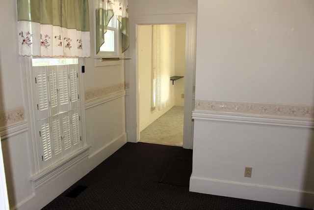 corridor with dark colored carpet and visible vents