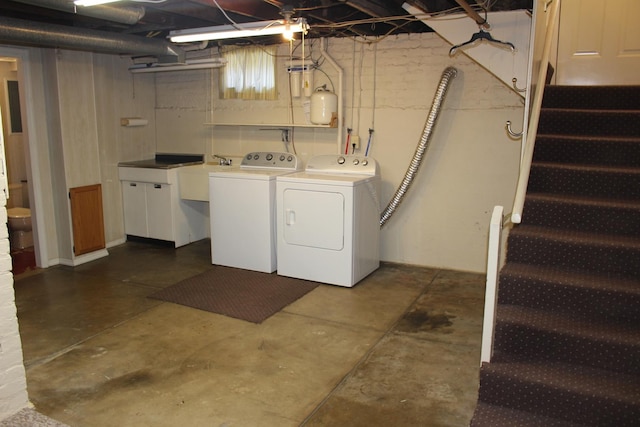 clothes washing area with washing machine and clothes dryer, a sink, and laundry area