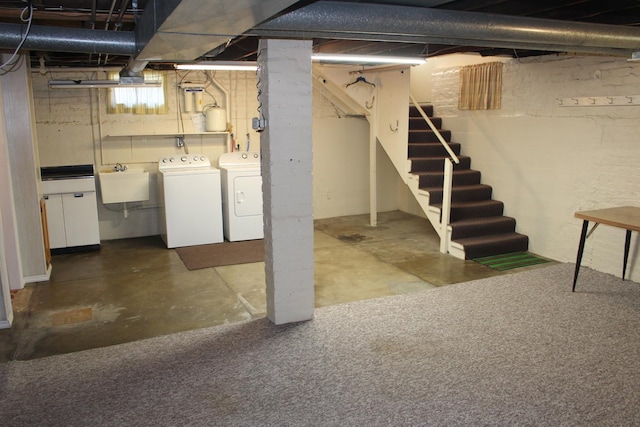 basement featuring stairway, a sink, and washer and clothes dryer