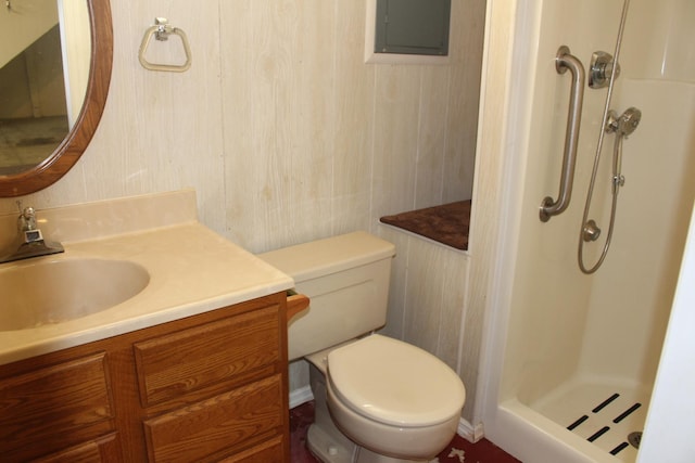bathroom with a stall shower, vanity, toilet, and electric panel