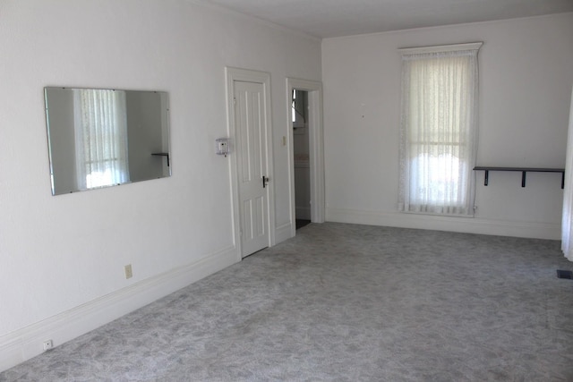 carpeted spare room featuring crown molding and visible vents