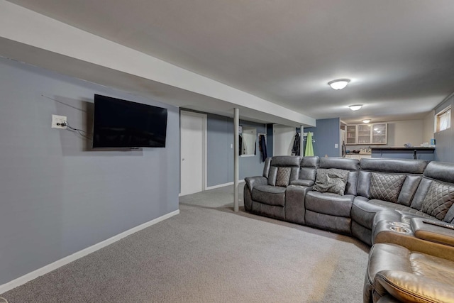 carpeted living room featuring baseboards and bar area