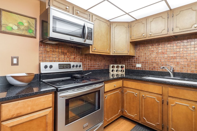 5300 Walnut Ave Unit 4D, Downers Grove, IL 60515 - kitchen with a sink, dark stone counters, brown cabinets, tasteful backsplash, and appliances with stainless steel finishes