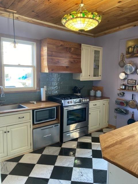 kitchen featuring appliances with stainless steel finishes, light floors, and wood ceiling