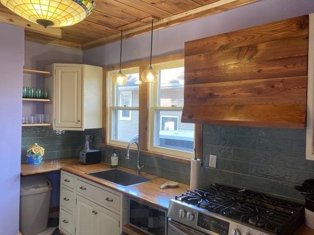 kitchen with a sink, white cabinets, gas range, wooden ceiling, and tasteful backsplash