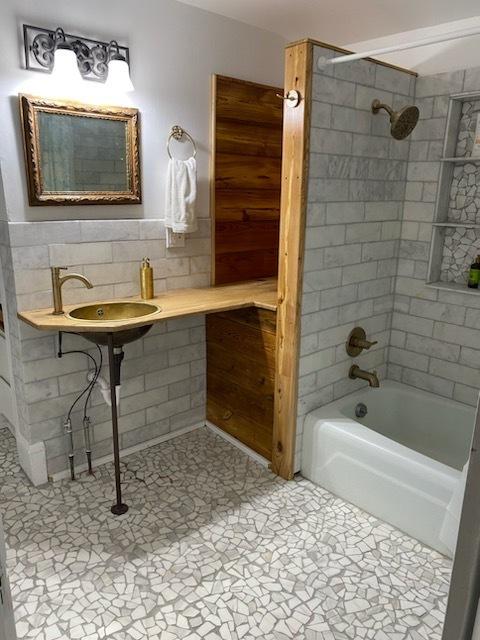 full bath with  shower combination and a sink