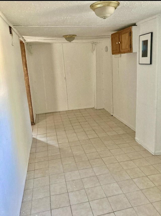 unfurnished room with light tile patterned flooring and a textured ceiling