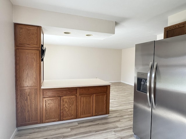 kitchen with stainless steel fridge, baseboards, and light wood-style floors