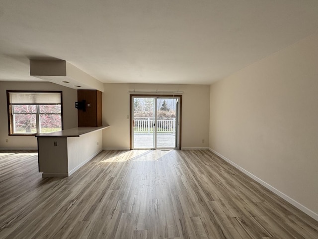unfurnished living room with baseboards and wood finished floors