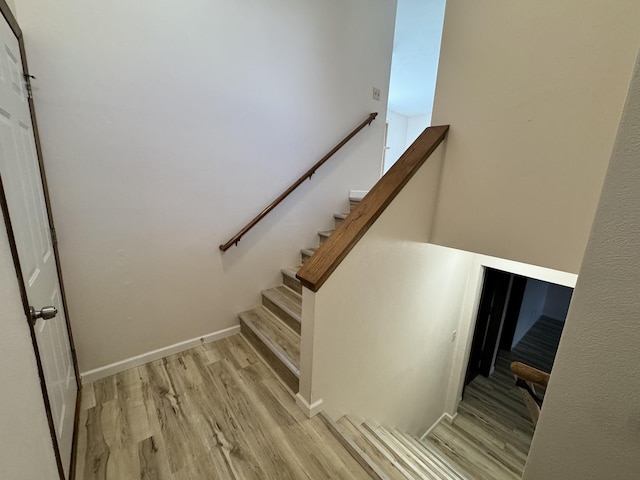 stairs featuring wood finished floors