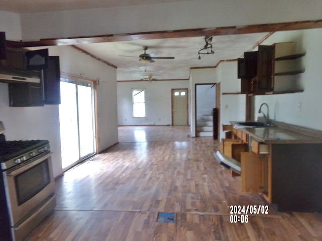 kitchen featuring gas range, open shelves, a sink, ceiling fan, and wood finished floors