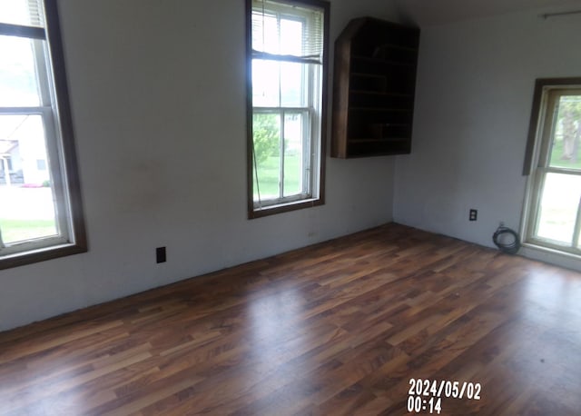 unfurnished room featuring healthy amount of natural light and dark wood finished floors