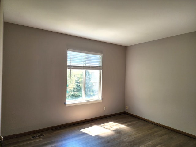 spare room featuring wood finished floors and baseboards