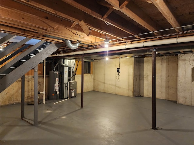 unfinished below grade area featuring gas water heater and heating unit