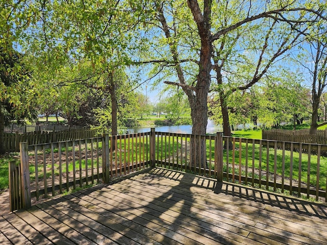 deck with a water view and view of wooded area