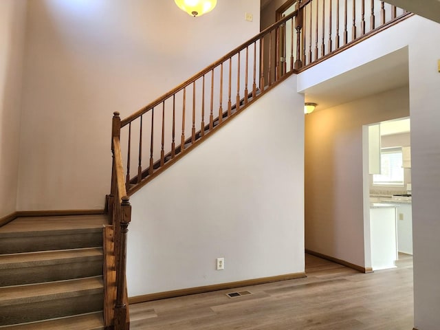 stairway featuring wood finished floors and baseboards