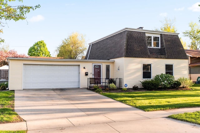 colonial inspired home featuring an attached garage, a front yard, a shingled roof, and driveway