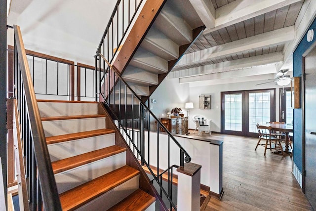 stairway featuring beamed ceiling, a ceiling fan, and wood finished floors