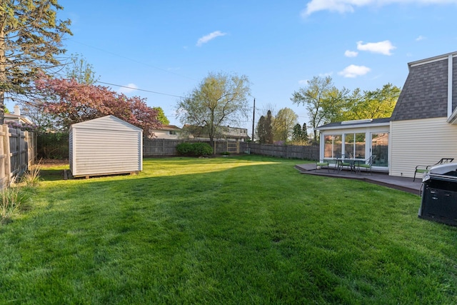 view of yard with a storage shed, an outdoor structure, a patio area, and a fenced backyard