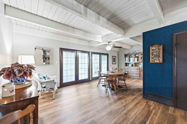 dining room featuring beamed ceiling, ceiling fan, and wood finished floors