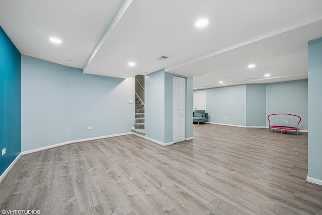 finished below grade area with wood finished floors, stairway, baseboards, and recessed lighting