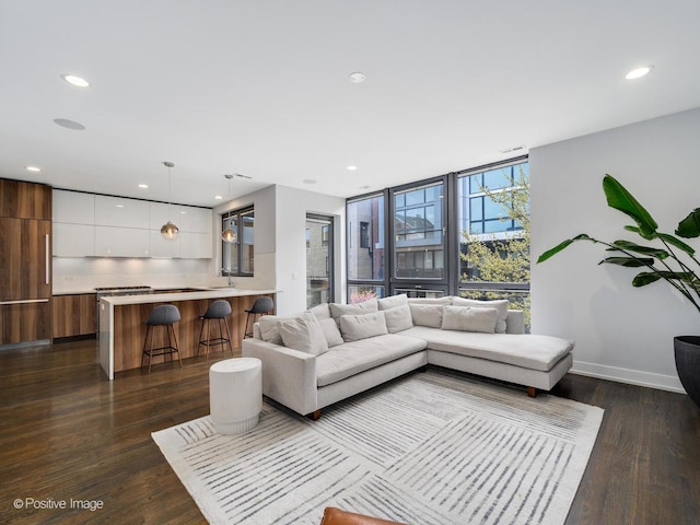 living room featuring floor to ceiling windows, recessed lighting, baseboards, and dark wood finished floors