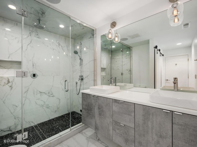 bathroom with a marble finish shower, visible vents, marble finish floor, and a sink