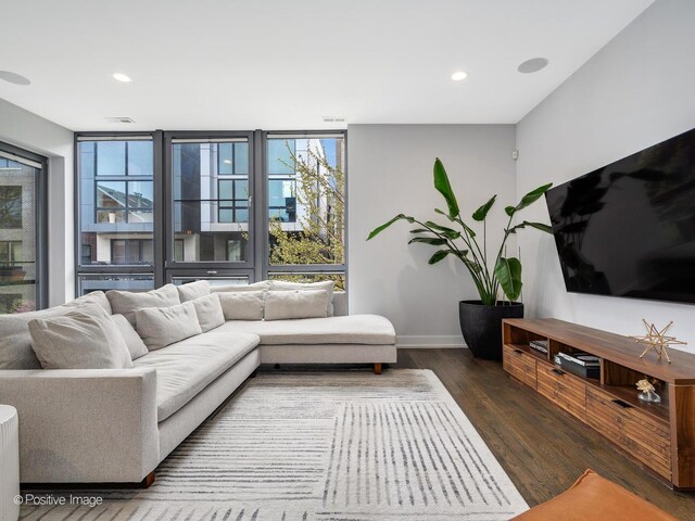 living area featuring recessed lighting, baseboards, a healthy amount of sunlight, and wood finished floors