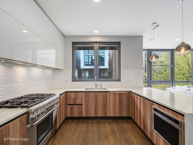 kitchen featuring brown cabinetry, high end stainless steel range, a wealth of natural light, and modern cabinets