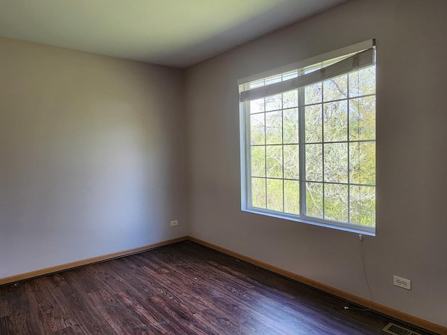 unfurnished room featuring plenty of natural light, baseboards, and dark wood-style floors