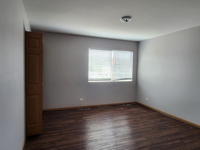 spare room featuring wood finished floors and baseboards