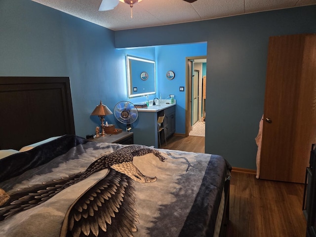 bedroom featuring a sink, dark wood-style flooring, baseboards, and ceiling fan