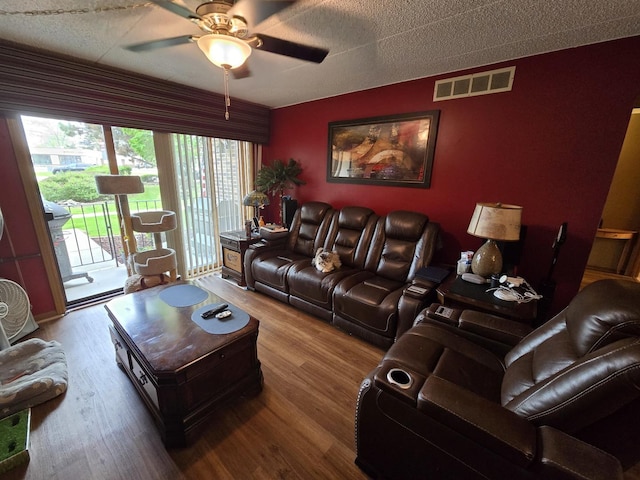 living area featuring ceiling fan, visible vents, and wood finished floors
