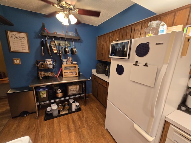 bar featuring freestanding refrigerator, a textured ceiling, a ceiling fan, and wood finished floors