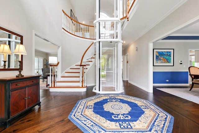 entryway with stairway, dark wood-type flooring, baseboards, a high ceiling, and crown molding