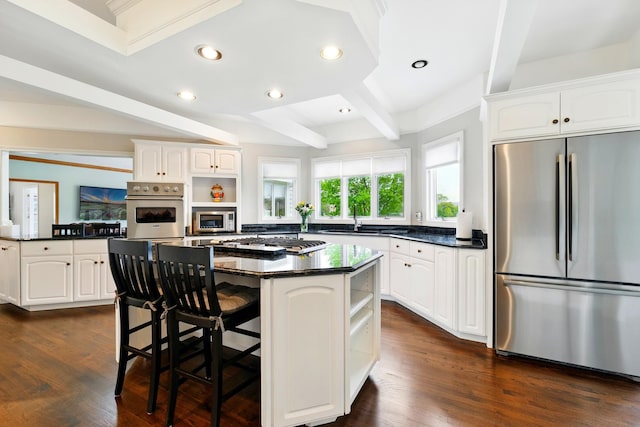 kitchen with appliances with stainless steel finishes, open shelves, dark countertops, beam ceiling, and white cabinetry