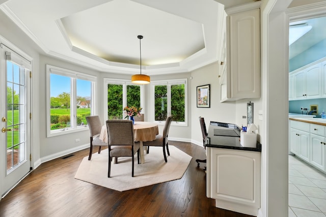 dining room with a raised ceiling, dark wood-style floors, and baseboards