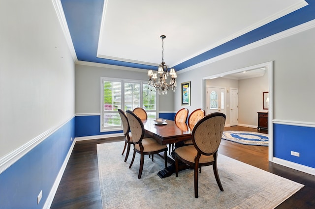 dining room featuring a chandelier, wood finished floors, baseboards, crown molding, and a raised ceiling