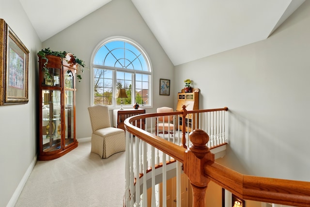 living area featuring lofted ceiling, an upstairs landing, carpet floors, and baseboards