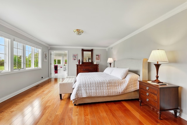 bedroom featuring light wood-style flooring, ornamental molding, and baseboards