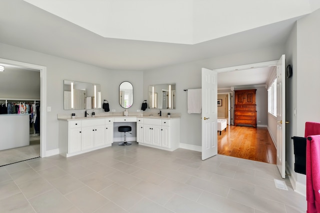 full bathroom with plenty of natural light, baseboards, and vanity
