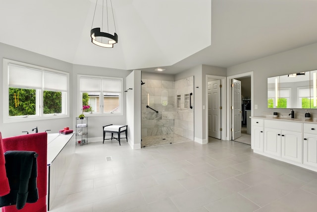 full bathroom featuring a stall shower, baseboards, vanity, tile patterned flooring, and a walk in closet