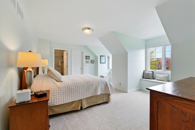 bedroom with light colored carpet, baseboards, and connected bathroom