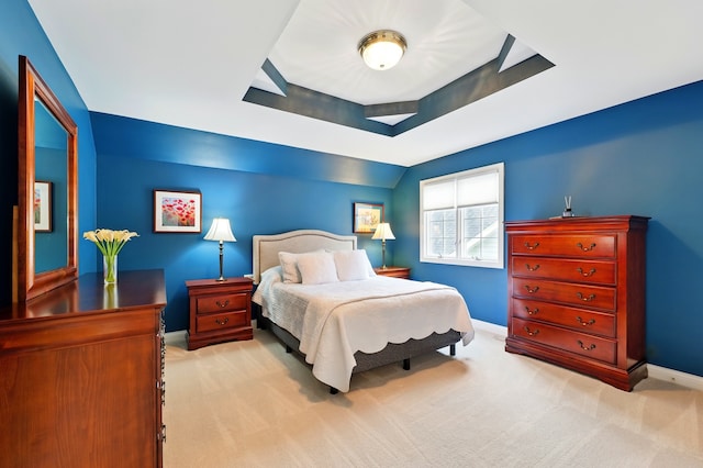 bedroom with baseboards, carpet floors, and a raised ceiling